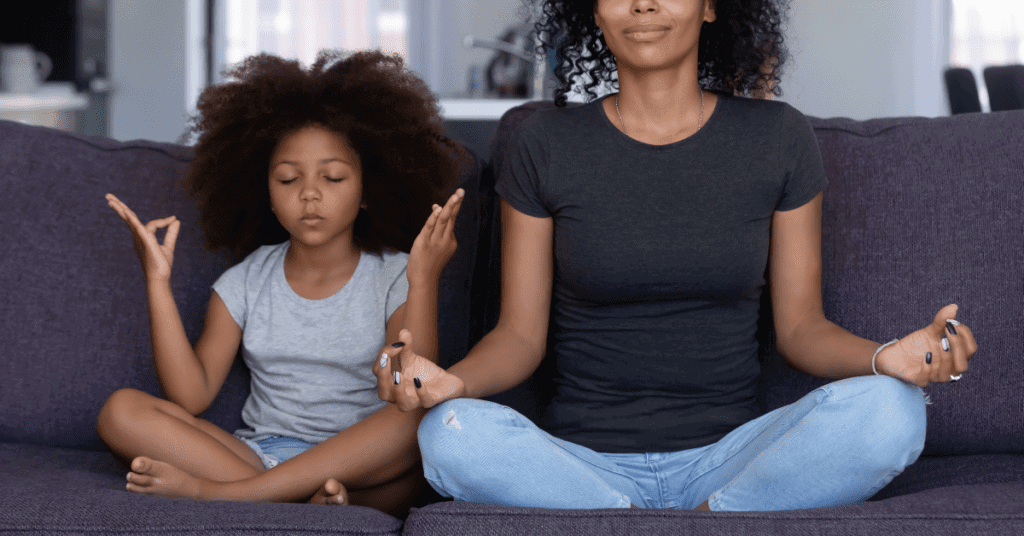 Meditation with a mother and daughter sitting on a sofa.