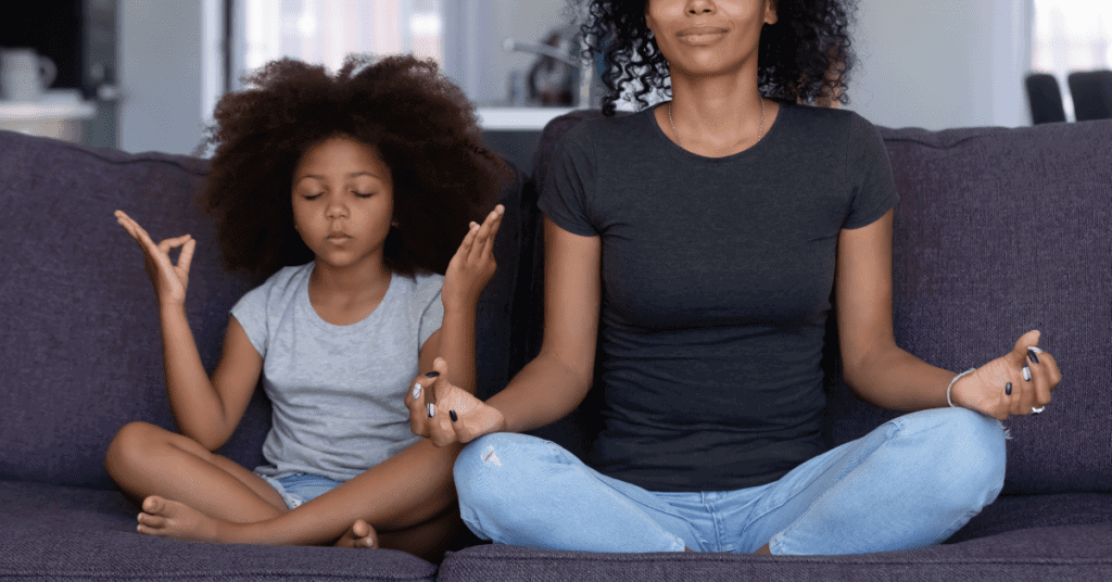 Meditation with a mother and daughter  sitting on a sofa. 