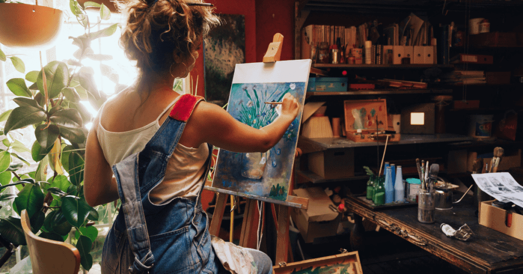 Young woman painting in her art studio to improve her mood