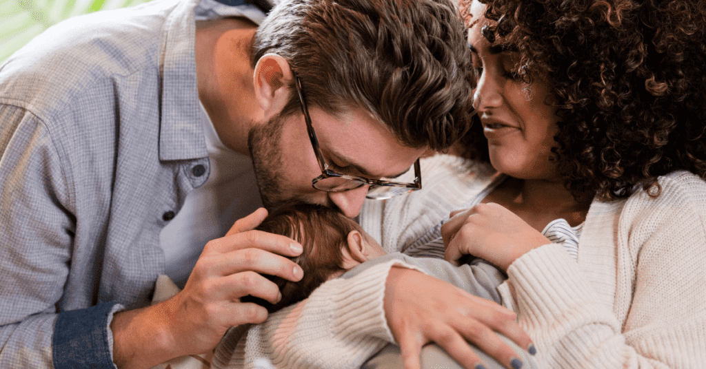 A new dad and new mum embracing their newborn baby