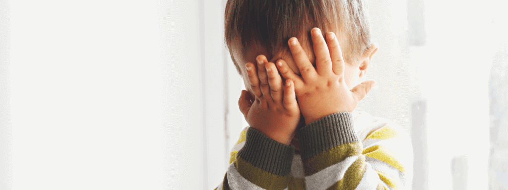 little boy covering his eyes