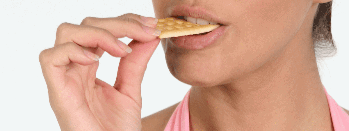 woman eating a plain cracker to ease morning sickness