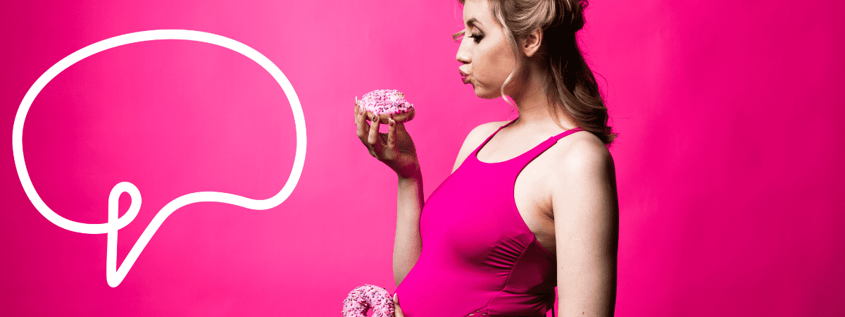 In an article discussing weird pregnancy cravings, a pregnant woman stares down at a doughnut she holds in one hand while holding another doughnut down by her baby bump.