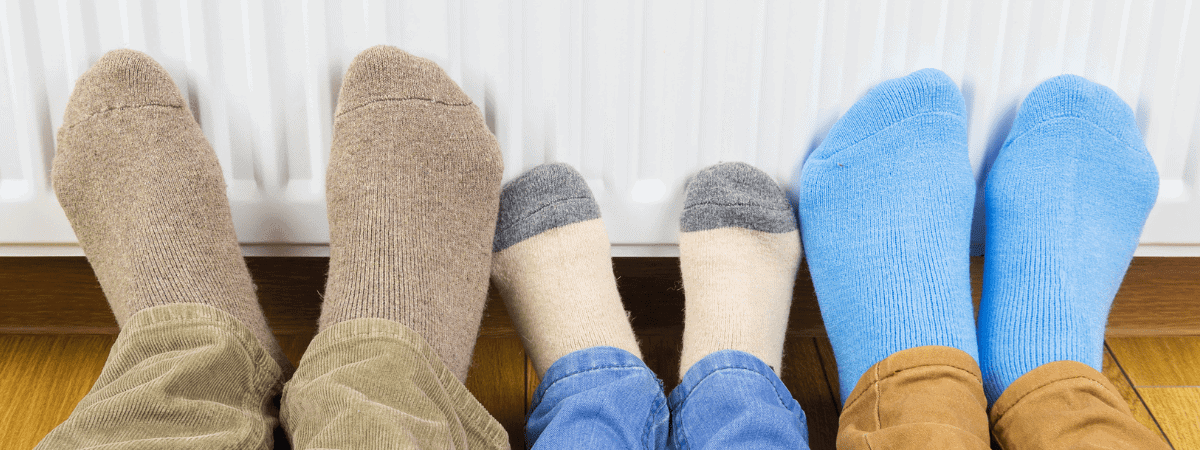 energy saving tips. -family warming feet against the radiator