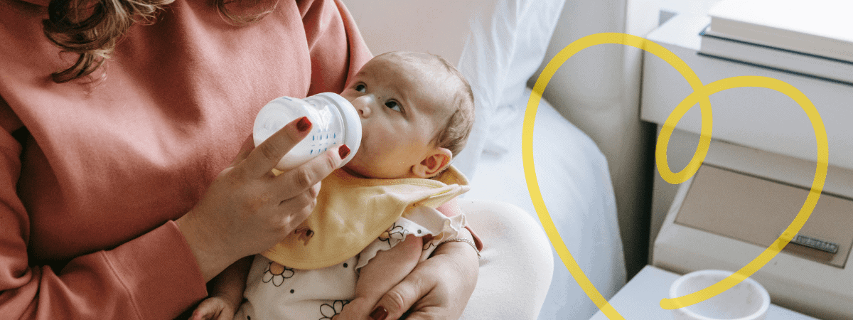 A newborn gazes up at their mother as they are bottle-fed 