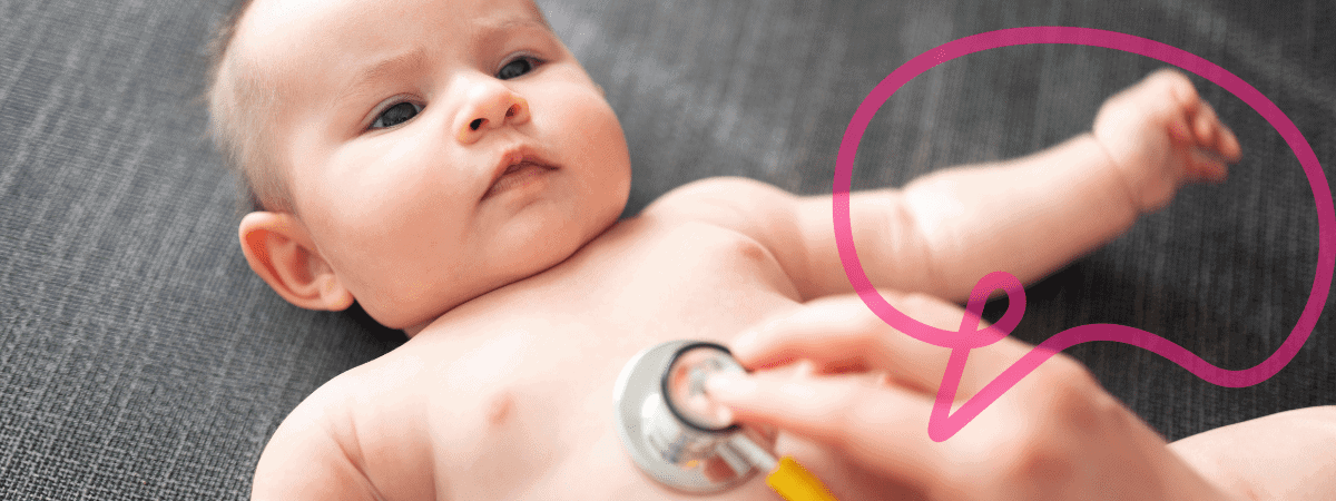 A baby looks up curious while a stethoscope is pressed to their stomach. 