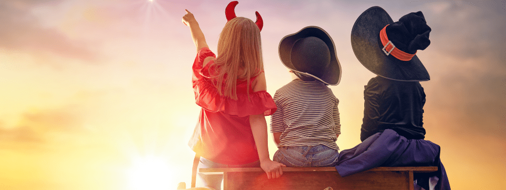 3 toddlers stare up in the sky, dressed up in their Halloween costumes