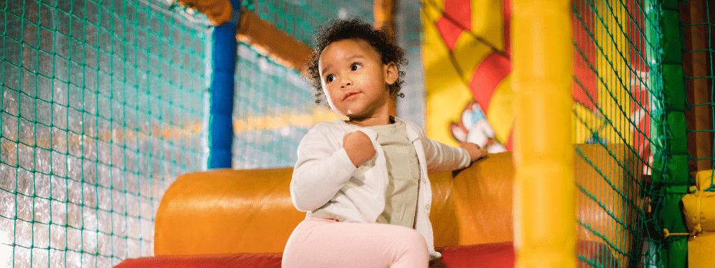 Mother's day activities: the image shows a small toddler climbing across a soft play obstacle