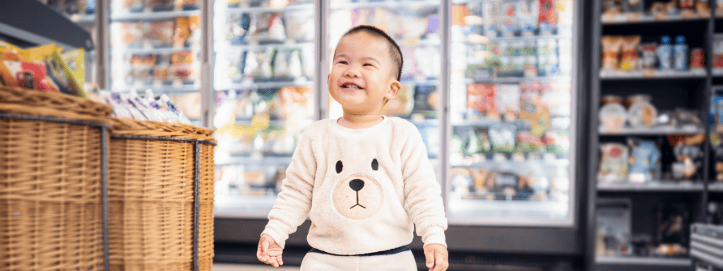 Father's day activities: a small child smiles toothily in a supermarket