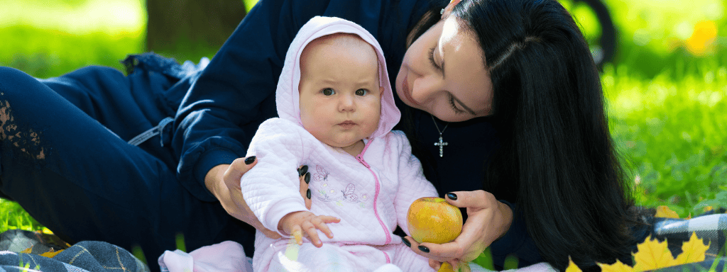 Leicester things to do with a baby or toddler: Image shows woman holding her baby while out in the park