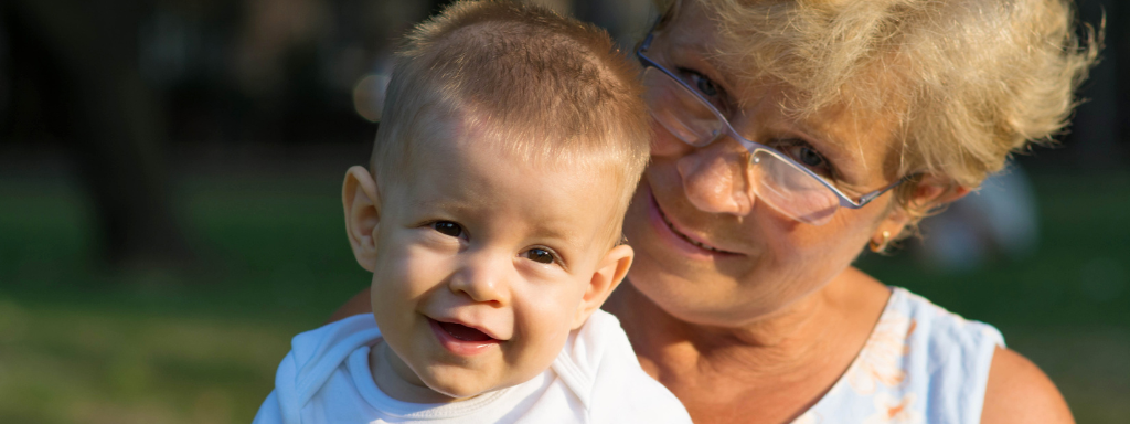 Baby First Photo Book - image shows a baby sitting with their grandmother