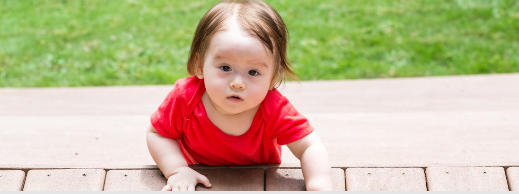 Baby photo books - image shows a baby outside on a panel flooring