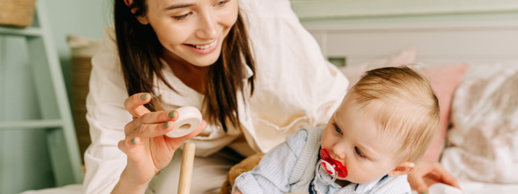 Finding support after parental leave - image shows a mother and her baby with a toy.