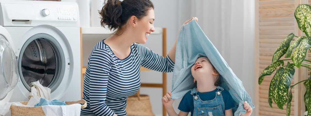 Developmental Activities With Your Toddler - Image shows a mother and her toddler playing with laundry