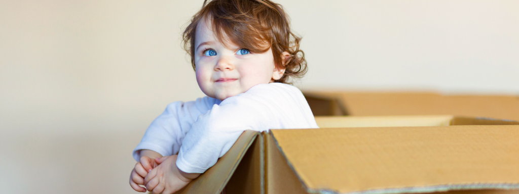 Developmental Activities With Your Toddler - Image shows a toddler sat inside a box