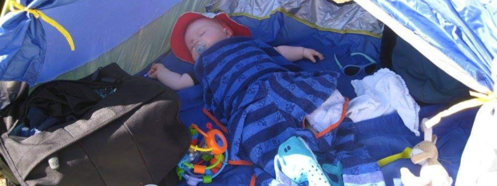 baby sleep - image shows a baby asleep outdoors within a tent.