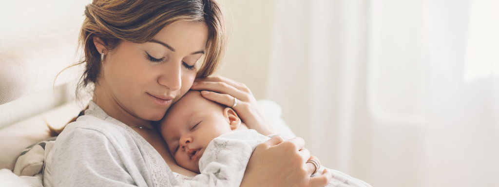 sleep for your baby - image shows a mother holding her baby while they sleep