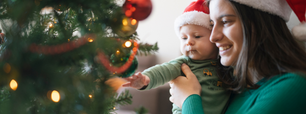Christmas as a single parent - image shows a mother and a baby looking at a Christmas tree