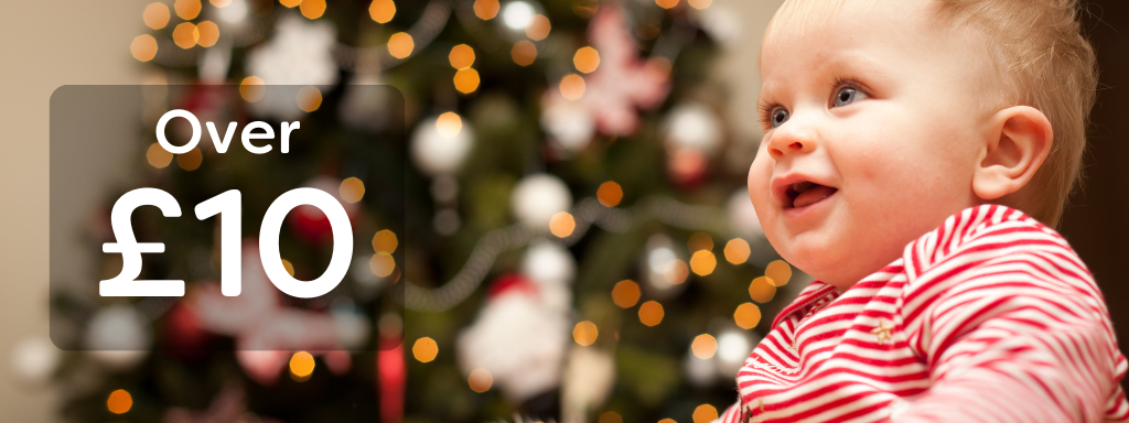 Stocking fillers over £10 - image shows a happy baby in front of a christmas tree