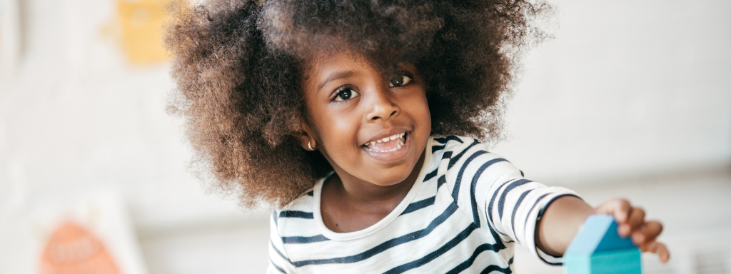 free childcare hours update - image shows a young child playing with a building block