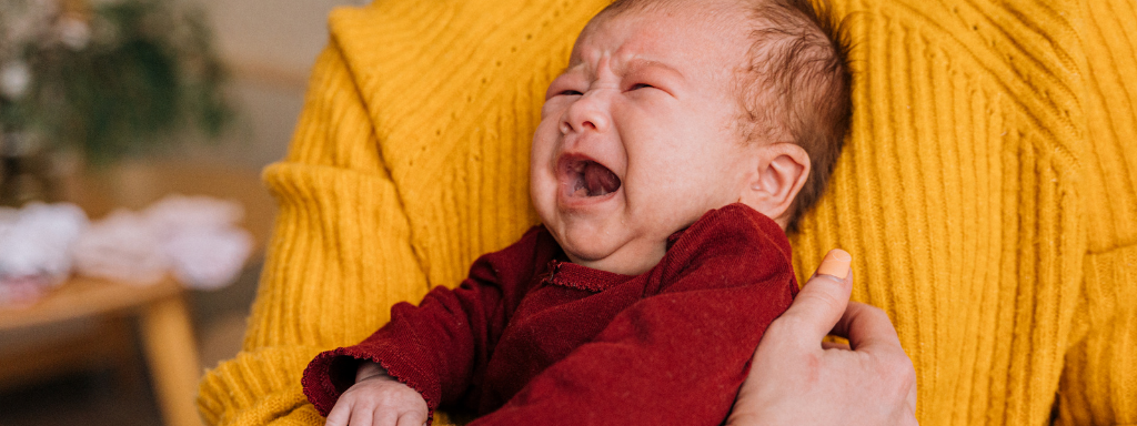 image shows a baby crying.