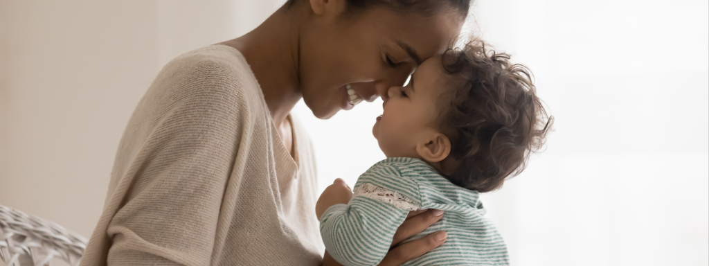 A mum and baby rub noses while smiling