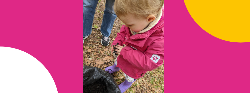 A toddler places soil in a pot