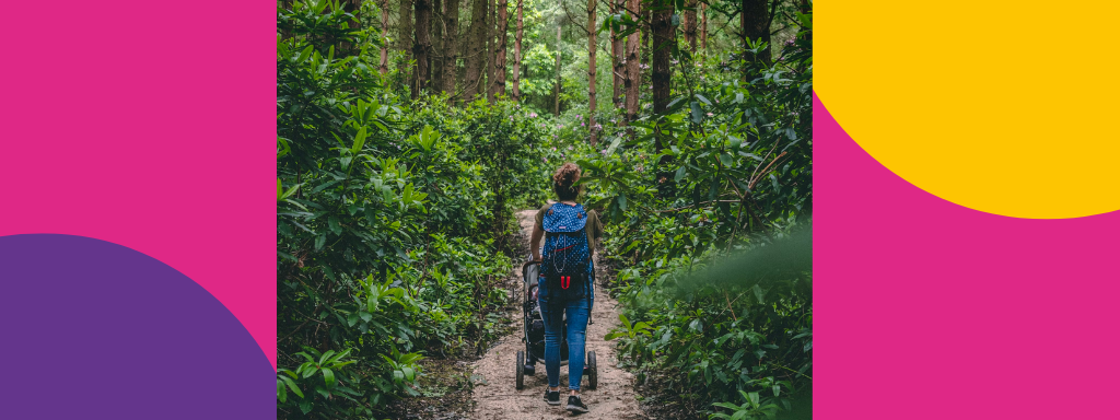 A mum goes for a walk through the woods, pushing a buggy