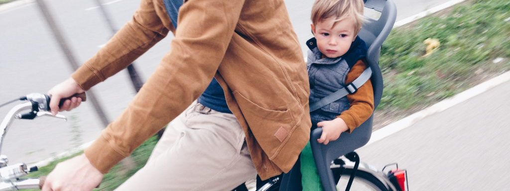 relieve stress as a parent - the photograph shows a child in a bike seat on the back of a bicycle