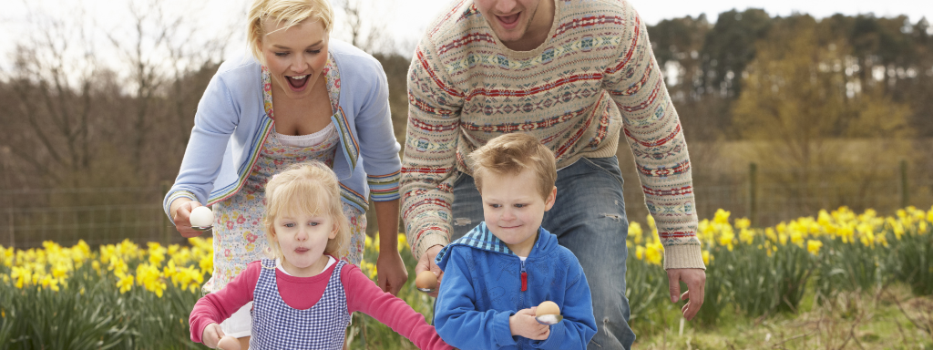 baby shower games - the photographs shows a man, woman and two children taking part in an egg and spoon race
