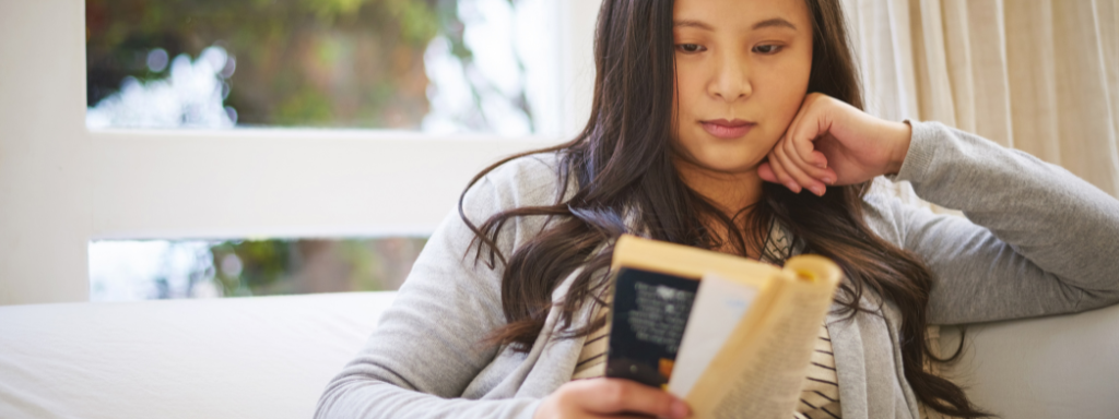 parenting books -the photo shows a pregnant woman looking at a book